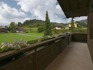 ロイテにあるApartment in W ngle Tyrol with Walking Trails Nearの花の咲くバルコニーから野原の景色を望めます。