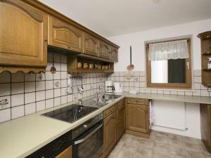 una cocina con armarios de madera y fregadero en Apartment in W ngle Tyrol with Walking Trails Near, en Reutte