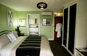 a bedroom with a bed in a room with green walls at Kinsellas Water Views in Albany