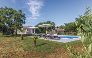una piscina con sillas y sombrillas junto a una casa en Awesome Home In Cubani With 2 Bedrooms, Wifi And Outdoor Swimming Pool, en Crnibek