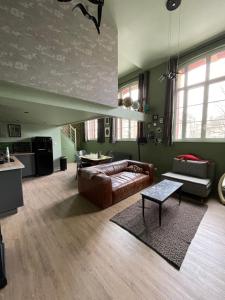 een woonkamer met een bank en een tafel bij "Curiosités", place de parking privative, centre ville in Dieppe