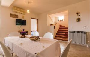 a dining room with a white table and chairs at Amazing Apartment In Pula With 2 Bedrooms And Wifi in Banjole