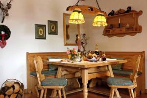 ein Esstisch mit Stühlen und einem Holztisch und Lichtern in der Unterkunft Ferienwohnung Am Panoramaweg in Bodenmais