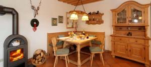 ein Esszimmer mit Tisch und Holzofen in der Unterkunft Ferienwohnung Am Panoramaweg in Bodenmais