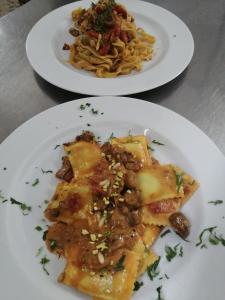 dois pratos de comida com massas e feijões numa mesa em Albergo Ristorante Giuliana em Guarcino