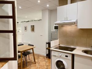 cocina con lavadora y mesa en Apartamento Puerta del Camino 3, en Bilbao