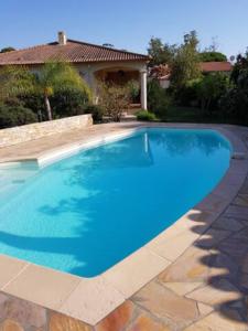 een blauw zwembad voor een huis bij Chambre d'hôte Kalango proche de la plage-Piscine in Lucciana