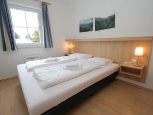 a large white bed in a room with a window at Apartment in St Margarethen in the ski area in Sankt Margarethen im Lungau