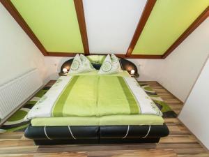 sypialnia z dużym łóżkiem z zieloną pościelą w obiekcie Apartment in Tröpolach near Nassfeld Gondola w mieście Tröpolach