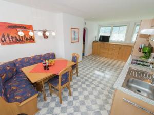 kuchnia i salon ze stołem i kanapą w obiekcie Apartment in Tröpolach near Nassfeld Gondola w mieście Tröpolach