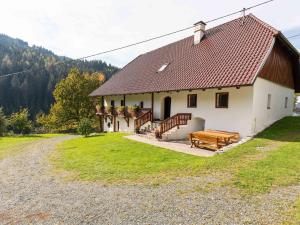 Biały budynek z ławką i domem w obiekcie Holiday home in Eberstein Carinthia with sauna w mieście Eberstein