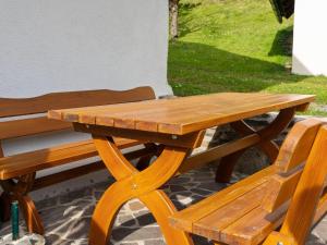 a wooden picnic table next to a bench at Holiday home in Eberstein Carinthia with sauna in Eberstein