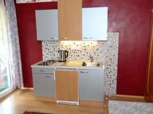 a small kitchen with white cabinets and a sink at Charming Apartment in Feld am See 100 m from Lake in Feld am See