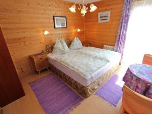 a bedroom with a bed and a wooden wall at Charming Apartment in Feld am See 100 m from Lake in Feld am See