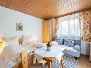 伊特爾的住宿－Apartment in Tyrol 100 m to the mountain railway，一间卧室配有一张床、一张桌子和一张沙发