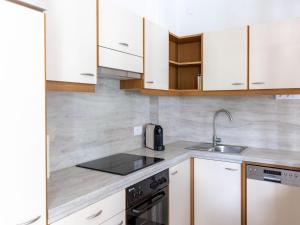 a kitchen with white cabinets and a sink at Gailtaler apartment at an excursion location in Kötschach