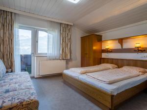 a bedroom with two beds and a window at Large mountain view apartment in Piesendorf Walchen Salzburgerland with balcony in Piesendorf