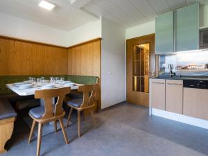 a dining room with a table and chairs and a kitchen at Large mountain view apartment in Piesendorf Walchen Salzburgerland with balcony in Piesendorf