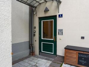 a green door on the side of a building at Comfortable Apartment in Zell am See near Forest in Zell am See