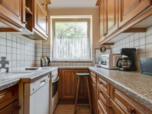 eine Küche mit Holzschränken und einem Fenster in der Unterkunft Lively Holiday Home in Wien with Private Garden in Wien