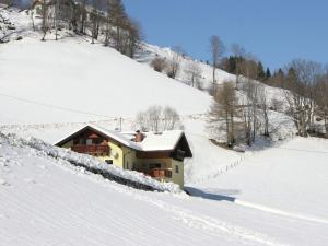 ein Haus im Schnee auf einem schneebedeckten Hang in der Unterkunft Posh Villa in Rennweg am Katschberg with Wellness and Bar in Rennweg