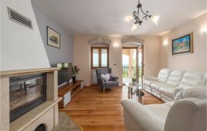 a living room with white furniture and a fireplace at Stunning Home In Labin With Outdoor Swimming Pool in Labin