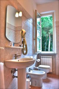 y baño con lavabo, espejo y aseo. en Hotel Villa Fiorisella, en Marina di Massa