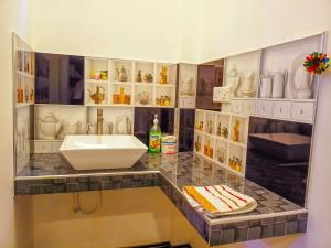 un bagno con lavandino e bancone con vasi di Sigiri Tarushan Home Stay a Sigiriya