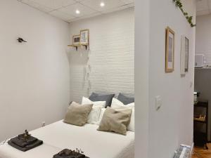 1 dormitorio con 1 cama con paredes y almohadas blancas en Apartamento Puerta del Camino 3, en Bilbao