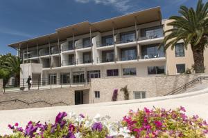 un bâtiment avec des fleurs devant lui dans l'établissement Thalazur Antibes - Hôtel & Spa, à Antibes