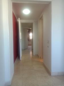 an empty hallway with white walls and a tile floor at new marina heart of Hurghada in Hurghada