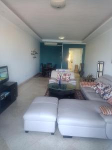new marina heart of Hurghada في الغردقة: غرفة معيشة مع كنبتين وتلفزيون