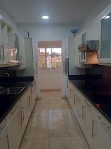 a large kitchen with white cabinets and black counter tops at new marina heart of Hurghada in Hurghada
