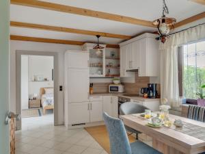 a kitchen with white cabinets and a wooden table at Cosy Apartment in Oed hling with Garden in Mauer bei Amstetten