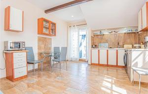 a kitchen with a table and chairs in a room at Amazing Apartment In Raslina With Kitchen in Raslina