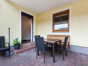 patio con mesa, sillas y ventana en Spacious Apartment in Grossarl with Garden, en Grossarl