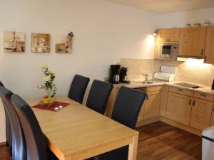 a kitchen with a wooden table and chairs in a kitchen at Apartment in Kaprun near ski lift in Kaprun