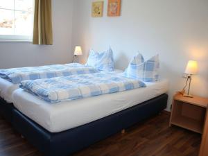 sypialnia z łóżkiem z niebiesko-białą pościelą i poduszkami w obiekcie Apartment in Kaprun near ski lift w Kaprunie