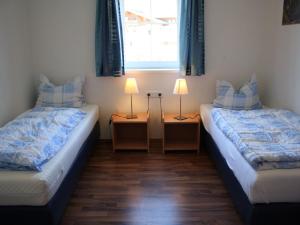 two beds in a room with two lamps and a window at Apartment in Kaprun near ski lift in Kaprun