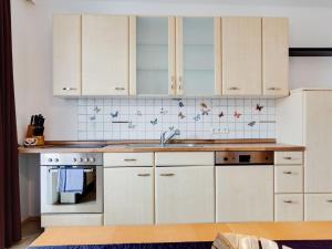 a kitchen with white cabinets and a sink at Beautiful Holiday Home in Ulrichsberg with Balcony in Ulrichsberg