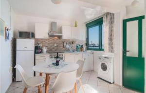 uma cozinha com uma mesa, electrodomésticos brancos e uma janela em Lovely Apartment In Kastel Gomilica With Kitchen em Kaštela