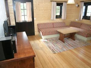 a living room with two couches and a coffee table at Apartment in Nassfeld Carinthia with sauna and pool in Schlanitzen