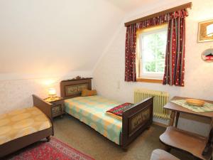 a bedroom with two beds and a table and a window at Holiday home Reiter I in Gmünd in Kärnten