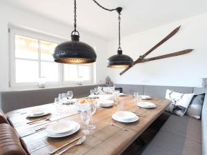 uma mesa de madeira com pratos e copos e um relógio em Modern apartment near the ski area em Brixen im Thale