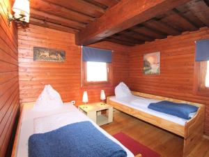 a bedroom with two beds in a wooden cabin at Modern holiday apartment in a renovated farmhouse in Fresach Carinthia in Fresach