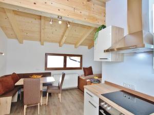 ホラースバッハ・イム・ピンツガウにあるWelcoming Apartment in Hollersbach im Pinzgau near Ski Areaの木製の天井とテーブル付きのキッチンとリビングルーム