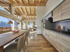 a kitchen with a long wooden table and chairs at Modern chalet in Saalbach Hinterglemm with sauna in Saalbach-Hinterglemm