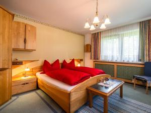 Un dormitorio con una cama con almohadas rojas y una mesa. en Blissful Apartment in Itter with a view, en Itter