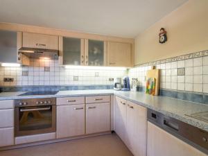una cocina con armarios blancos y encimeras grises en Blissful Apartment in Itter with a view, en Itter