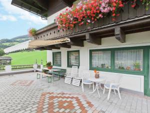 ホラースバッハ・イム・ピンツガウにあるLush Apartment in Hollersbach im Pinzgau with Terraceの花が咲くパティオ(テーブル、椅子付)